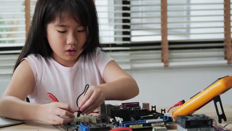 Niña-que-trabaja-solo-en-laboratorio,-ensamblando-y-probando-equipos-en-taller.-Personas-con-tecnología-y-concepto-de-innovación.