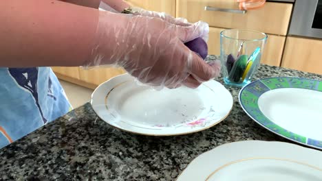 Eine-Frau-in-Handschuhen-malt-Eier