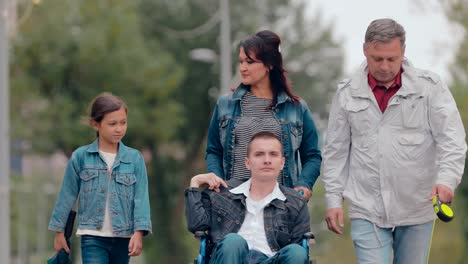 Disabled-young-man-on-a-walk-with-his-family.-Portrait-view.