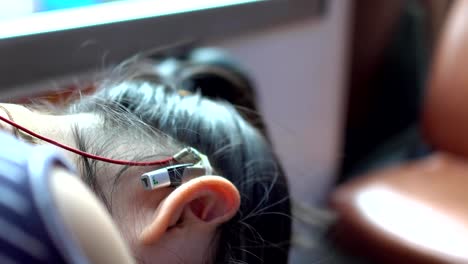 Hearing-loss-child-sleeping-on-the-seat.-In-the-shaking-bus.Over-the-shoulder-shot.