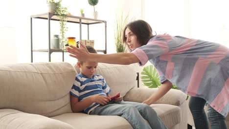 Mother-scolding-son-playing-game-on-mobile-phone