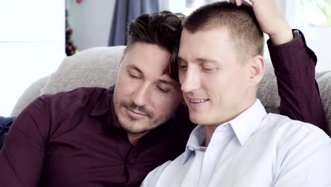 Gay-couple-relaxing-on-couch.-Rubbing-hair.