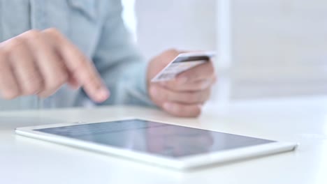 Close-Up-of-Young-Hands-using-Credit-Card-on-Tablet