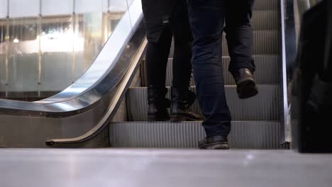 Piernas-de-personas-moviéndose-en-un-ascensor-de-escaleras-mecánicas-en-el-centro-comercial.-Pies-de-comprador-en-Escalera-Saltadora-en-el-Centro-Comercial