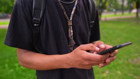 b-roll-guy-typing-message-on-mobile-outdoors