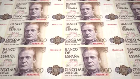 Banknotes-of-five-thousand-spanish-pesetas-of-the-bank-of-Spain-rolling-on-screen,-coins-of-the-world,-cash-money,-loop