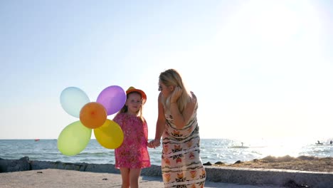 Disabled-man-in-wheelchair-with-family,-mother-goes-for-hand-with-daughter-beside-sea,-parents-with-child-on-open-air.