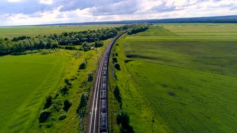 Aerial-shot-of-cargo-train-in-green-field.-4K.