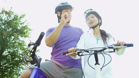 Pareja-hombre-mujer-asiática-China-ejercicios-bicicletas-juntos