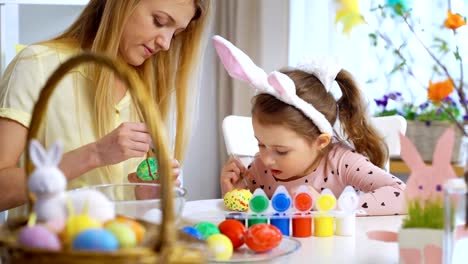 ¡Feliz-Pascua-de-resurrección!-Madre-y-su-pequeña-hija-con-divertidas-orejas-de-conejo-para-colorear-huevos-de-Pascua