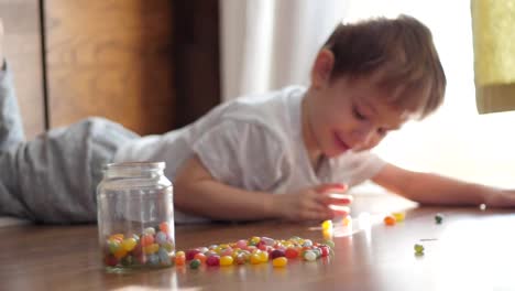 süsser-Boy-spielen-mit-bunten-Bonbons