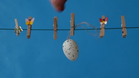 The-Easter-Eggs-is-hanging-on-the-clothesline-on-blue-background.