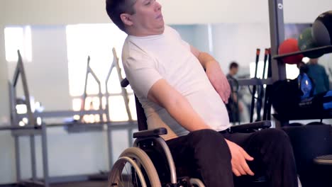 Full-view-of-disabled-man-in-wheelchair-warming-up-before-training.