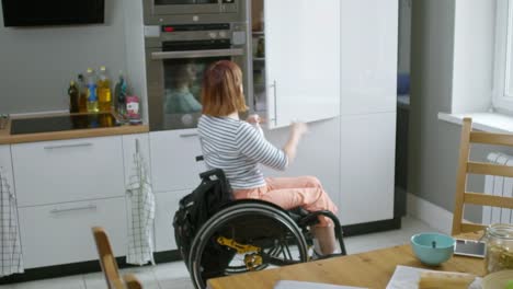 Woman-in-Wheelchair-Putting-Milk-in-Fridge