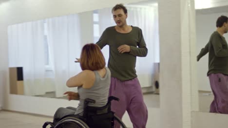 Talentosa-mujer-bailando-en-silla-de-ruedas-con-el-coreógrafo-masculino