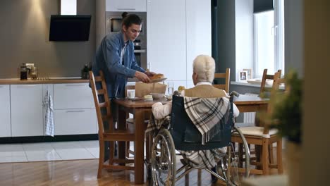 Junger-Mann-das-Frühstück-für-Senior-Lady