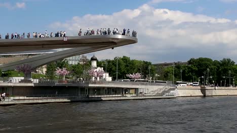 Floating-bridge-of-Zaryadye-park-on-Moskvoretskaya-Embankment-of-Moskva-River-in-Moscow,-Russia.-Shooting-from-a-tourist-pleasure-boat