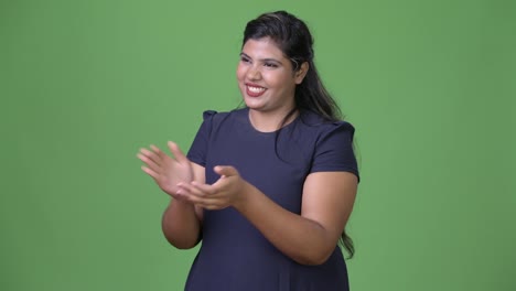 Young-overweight-beautiful-Indian-businesswoman-against-green-background