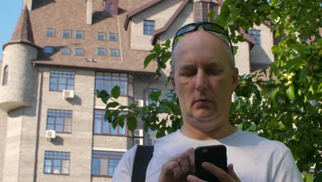 Adult-man-browsing-internet-on-smartphone-in-city