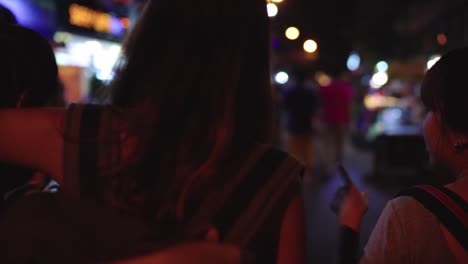 Slow-motion---Traveler-backpacker-Asian-women-lesbian-lgbt-couple-travel-in-Bangkok,-Thailand.-Female-drinking-alcohol-or-beer-at-The-Khaosan-Road-the-most-famous-street-in-Bangkok.