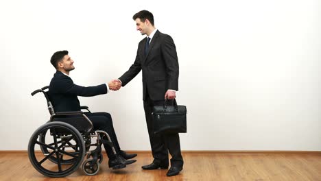 The-disabled-and-a-businessman-handshake-on-the-white-wall-background