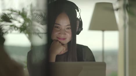 Young-woman-sitting-at-home-working-with-computer-and-chair-dancing