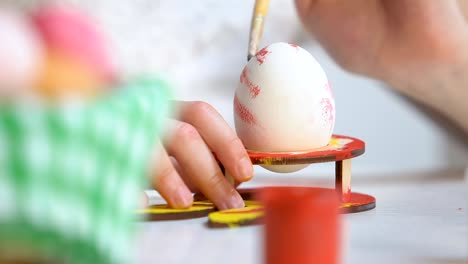 Manos-de-los-niños-dibujando-patrones-coloridos-en-huevo,-casa-preparación-para-la-Pascua