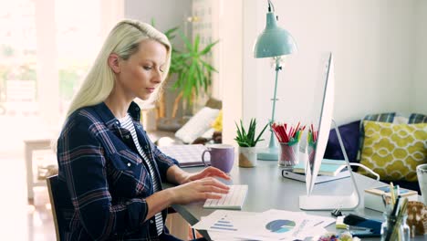 Schöne-blonde-Geschäftsfrau-tippen-am-Computer-zu-Hause-Büro