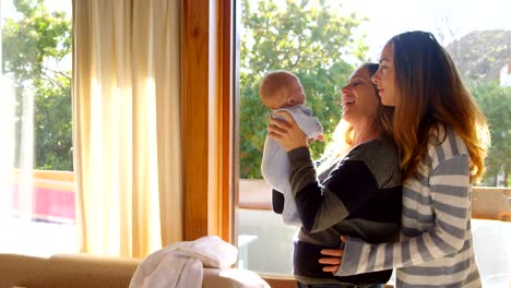 Lesbian-couple-holding-their-baby-boy-4k