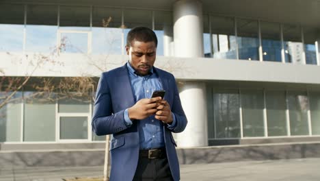 African-Businessman-Chatting-on-Cellphone-Outdoors