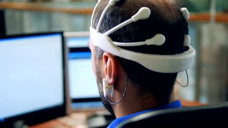 An-engineer-wearing-special-Brainwave-Scanning-sensors-on-a-head,-back-view.