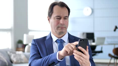 Middle-Aged-Businessman-Using-Smartphone,-Typing-Message