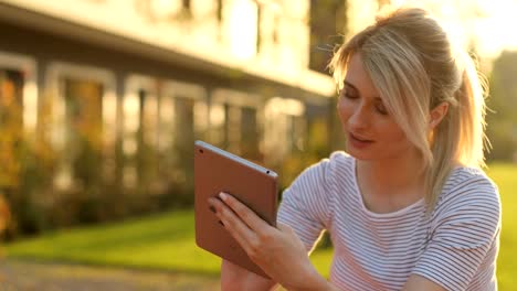 Junge-Studentin-mit-Tablet-Computer-im-Park.