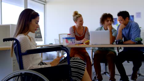 Side-view-of-young-Caucasian-disabled-female-working-on-digital-tablet-against-three-business-people