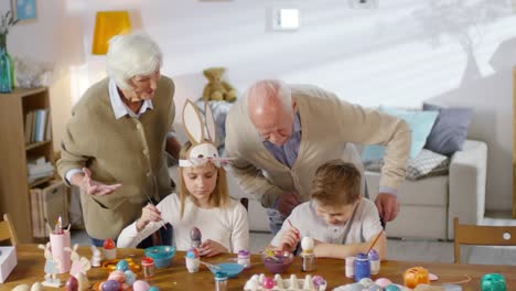 Grandparents-Watching-Grandchildren-Paint-Eggs