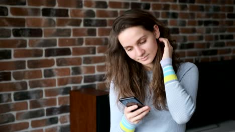 Hermosa-chica-hablando-en-el-teléfono-en-su-apartamento.