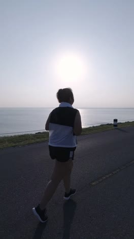 Vertical-Videos.-Asian-women-jogging-in-the-street-in-the-early-morning-sunlight-at-water-storage-Pa-Sak-Jolasid-Dam.-concept-of-losing-weight-with-exercise-for-health.-Rear-View