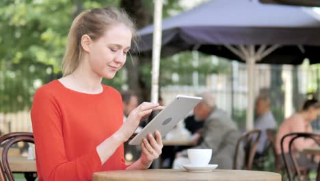 Junge-Frau-nutzt-Tablet,-Sitting-in-Cafe-Terrasse