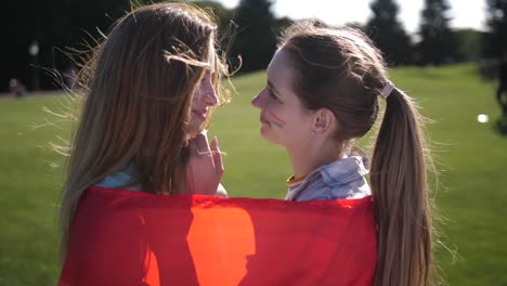 Happy-lesbians-enjoying-closeness-wrapped-in-flag