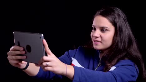 Closeup-portrait-of-adult-attractive-caucasian-female-having-a-video-call-on-the-tablet-with-background-isolated-on-black