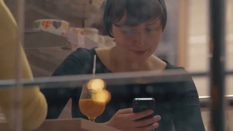 Women-having-friendly-meeting-in-cafe-and-being-attracted-with-mobiles