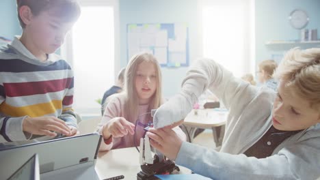 Elementary-School-Robotics-Classroom:-Diverse-Group-of-Brilliant-Children-Building-and-Programming-Robot,-Talking-and-Working-as-a-Team.-Kids-Learning-Software-Design-and-Creative-Robot-Engineering