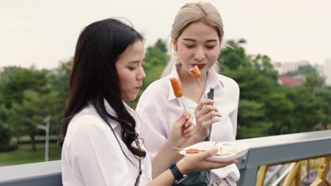 Asian-lesbian-couple-enjoying-traveling-in-Thailand-and-eating-meatball-having-fun-during-vacation-time.-LGBT-concept.