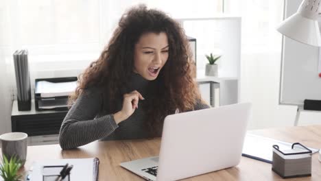 Mujer-de-negocios-asombrada-que-trabaja-en-la-computadora-portátil