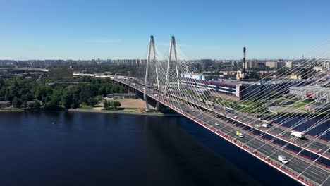 Aerial-or-top-view-from-drone-of-concrete-bridge-with-asphalt-road-or-highway-over-big-river-with-city-car-traffic,-urban-transportation,-toned