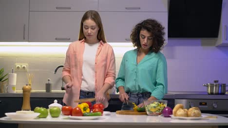 Mujer-caucásica-abrazando-a-amiga,-compañeras-de-cuarto-cocinando-juntas-en-casa