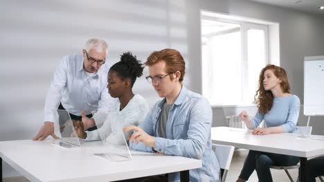 College-Studenten-arbeiten-an-transparenten-Touchscreen-Geräten-im-Unterricht