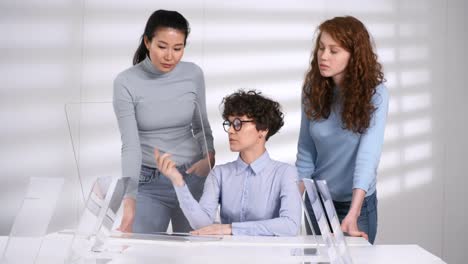 Profesora-y-estudiantes-caucásicos-que-miran-la-pantalla-táctil-interactiva-de-AR