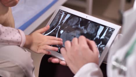 Médico-sosteniendo-tableta-con-escáneres-cerebrales-en-la-pantalla