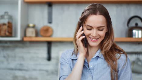 Close-up-face-adorable-blonde-girl-communicating-on-telephone-at-kitchen.-Shot-with-RED-camera-in-4K